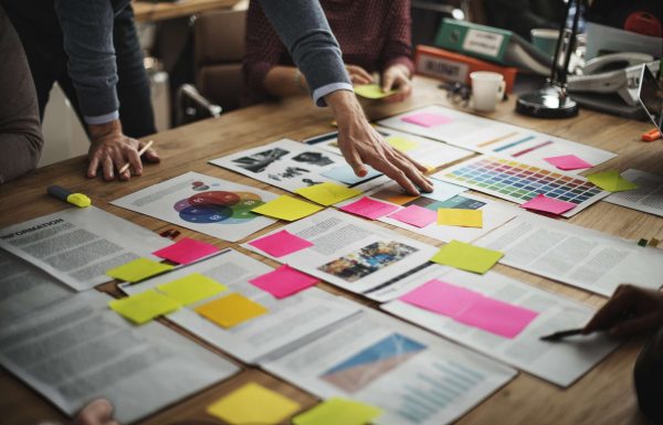 Branding Brainstorming on the table with colourful papers and people around the table.